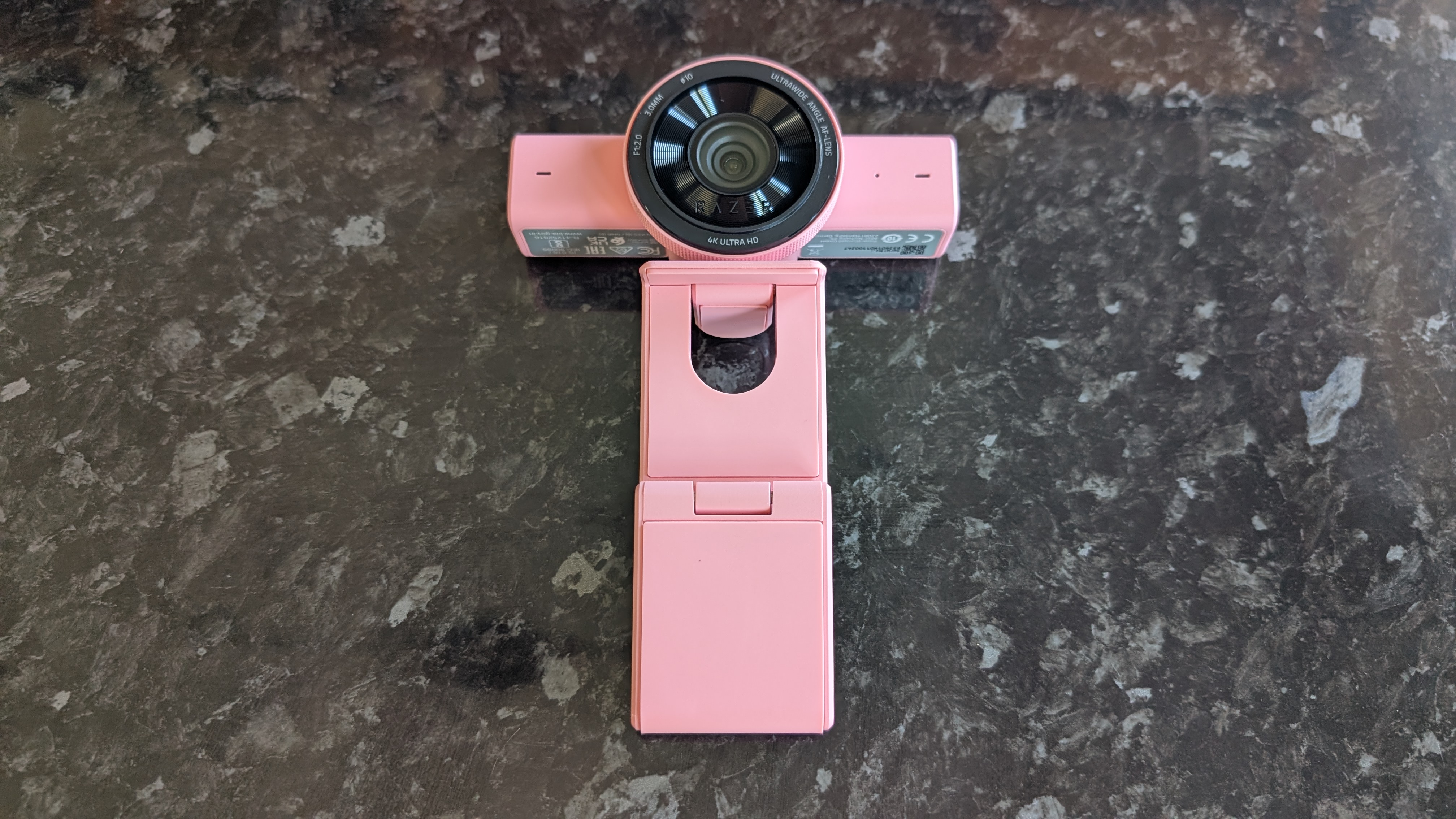 The Razer Kiyo V2 webcam pictured on a dark marble worksurface.