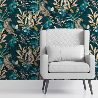 Detail shot of a smart grey armchair in front of a bold patterned wallpaper wall