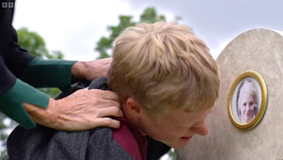 Cindy forces Bobby to look at the photograph on Lucy's grave