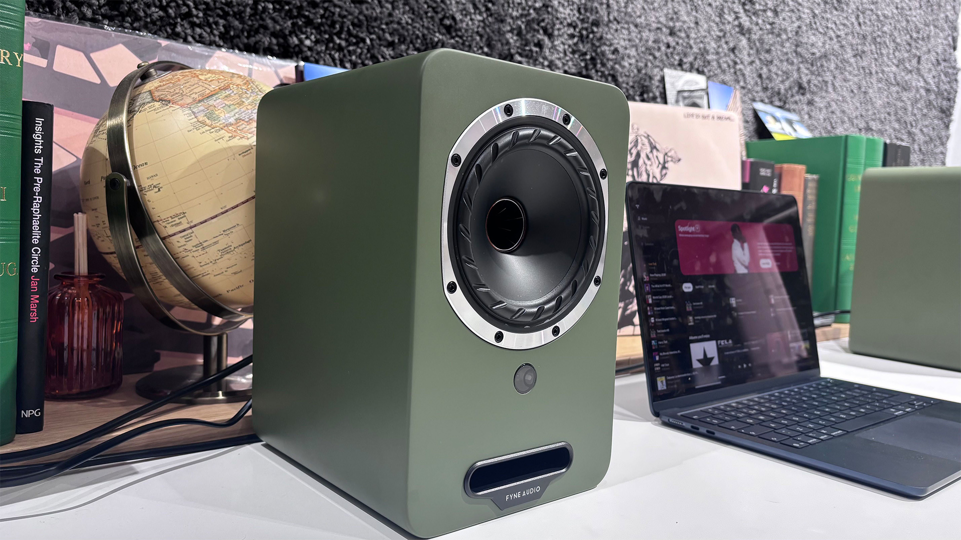 Fyne Audio Cubitt 5 speakers in olive green finish, placed on white table with records in background