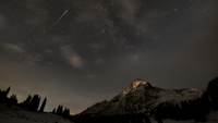 Shooting star above a snow mountain.