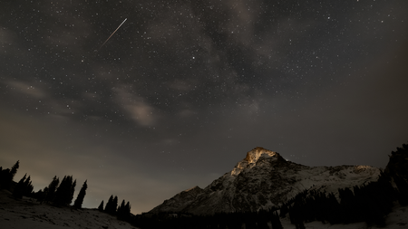 Shooting star above a snow mountain.
