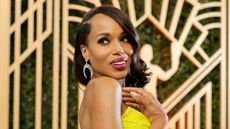 Kerry Washington's dining room is so chic. Here is the actor with a dark brown bob and pink lipstick wearing a bright yellow dress, standing in front of a gold panel