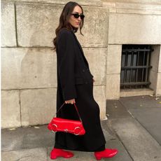 Woman wears black coat, red Gucci horsebit bag and red Steve Madden Cherish pumps.