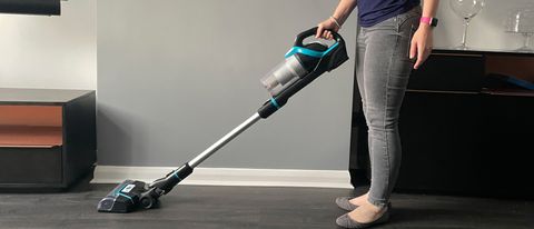 Bissell CleanView Pet Slim Cordless Stick Vacuum being used by a woman to vacuum a hard floor