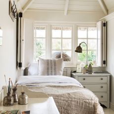 White spare room with single bed, chest of drawers and desk