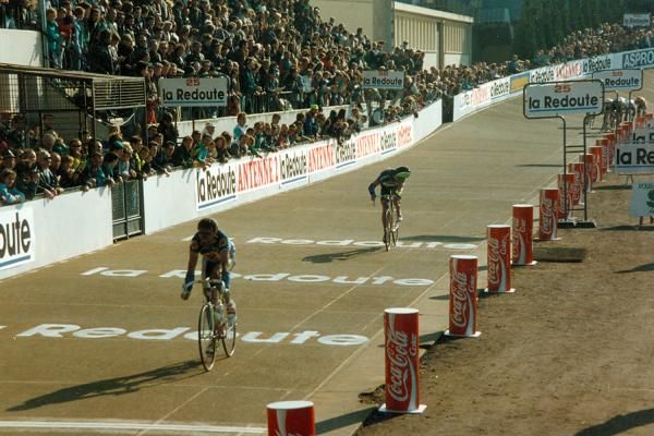 Riders cross the finish line inside Roubaix's velodrome during the 1990 edition.