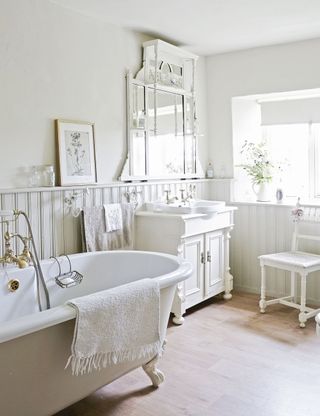 bathroom in Georgian cottage with white walls and tongue and groove paneling and decorative mirror
