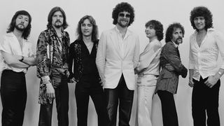 ELO standing in a row in front of a white wall