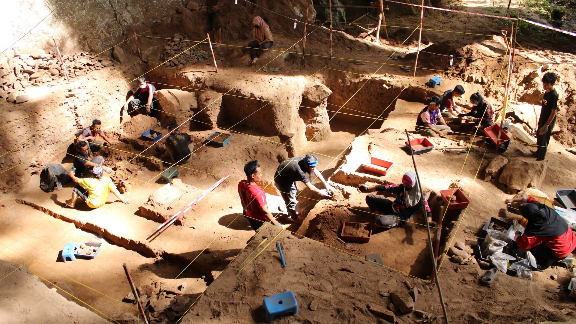 Um grupo de escavadores escava um grande sítio arqueológico