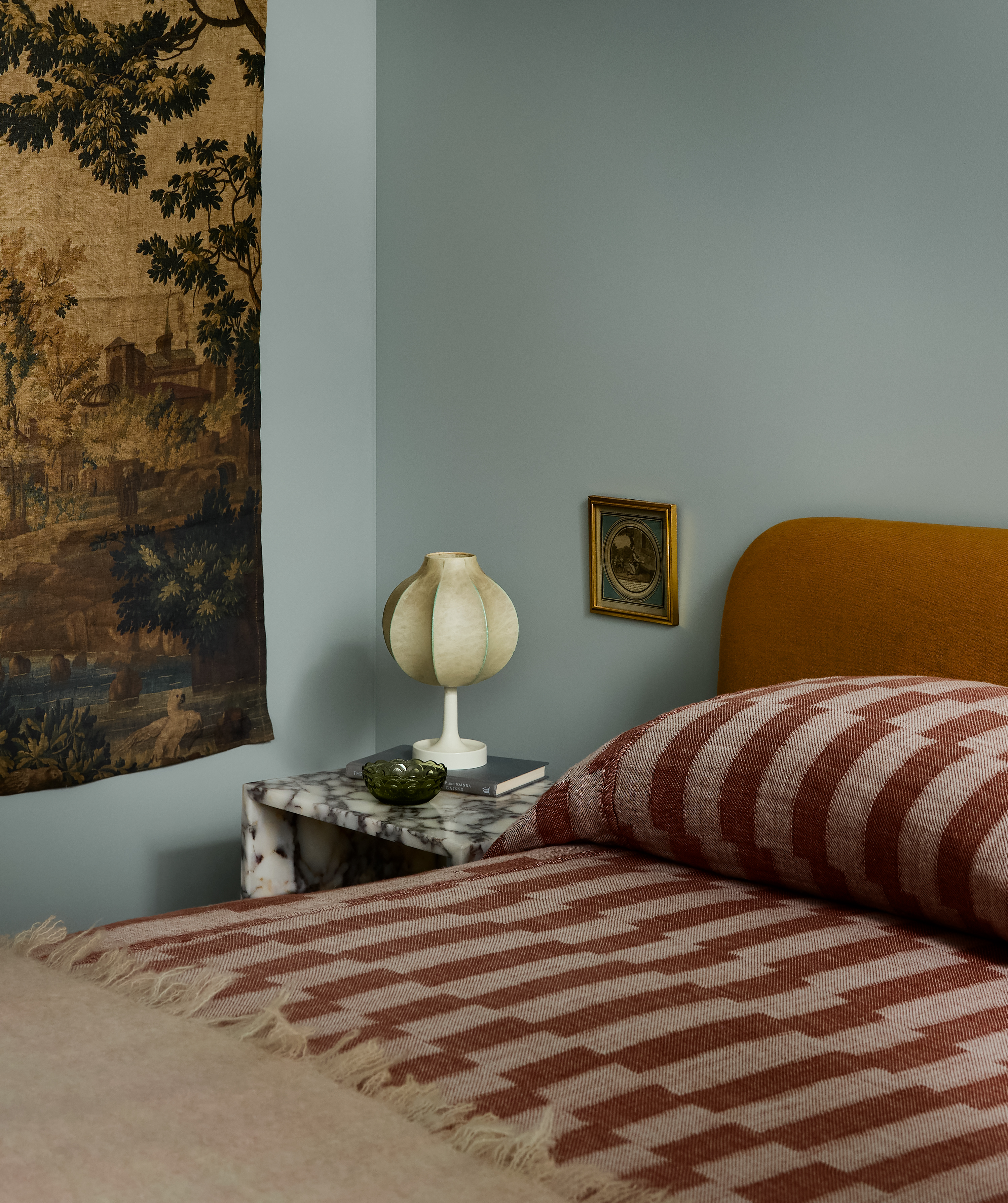 pale blue bedroom with accents of red, pink and mustard