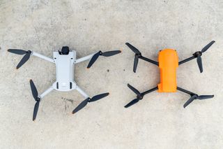The DJI Mavic Mini 3 Pro drone and the Autel EVO Nano+ drone on a concrete surface