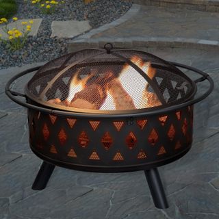 black fire pit with crossed metal design and mesh covering containing a fire inside