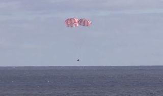 NASA's first Orion spacecraft parachutes down to a smooth water splashdown in the Pacific Ocean in this still image from a video recorded from the USS Anchorage, a Navy recovery ship that retrieved the capsule after its successful test flight on Dec. 5, 2014.