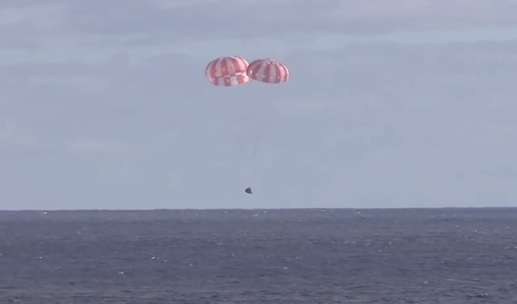 NASA&#039;s first Orion spacecraft parachutes down to a smooth water splashdown in the Pacific Ocean in this still image from a video recorded from the USS Anchorage, a Navy recovery ship that retrieved the capsule after its successful test flight on Dec. 5, 2