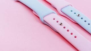 Two silicone Sport Band bands for the Apple Watch in pink and blue on a pink background