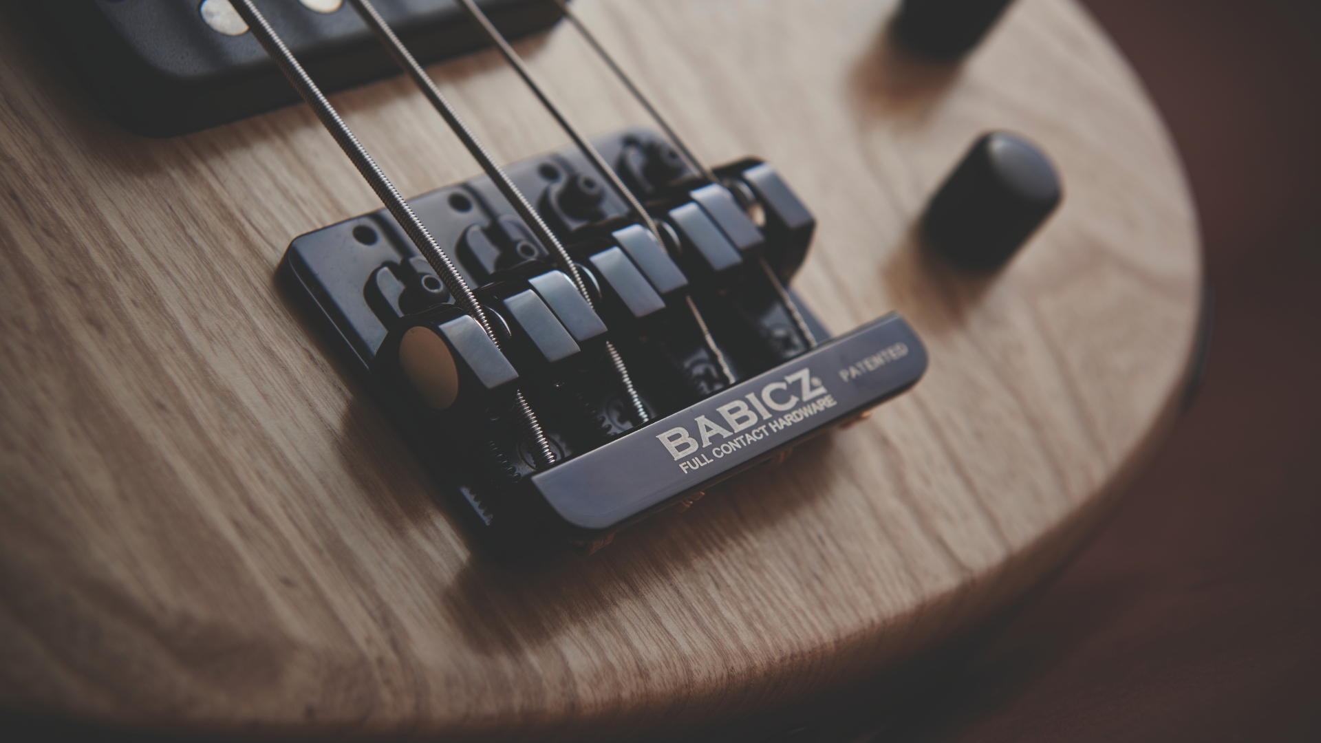 Close up of a Babicz bridge on a bass guitar