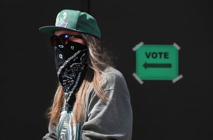 Photo of masked voter at poll