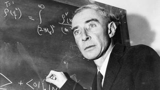 J. Robert Oppenheimer writing equations on a chalkboard.