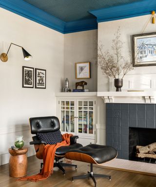 eames style leather chair and footstool near fireplace in living room