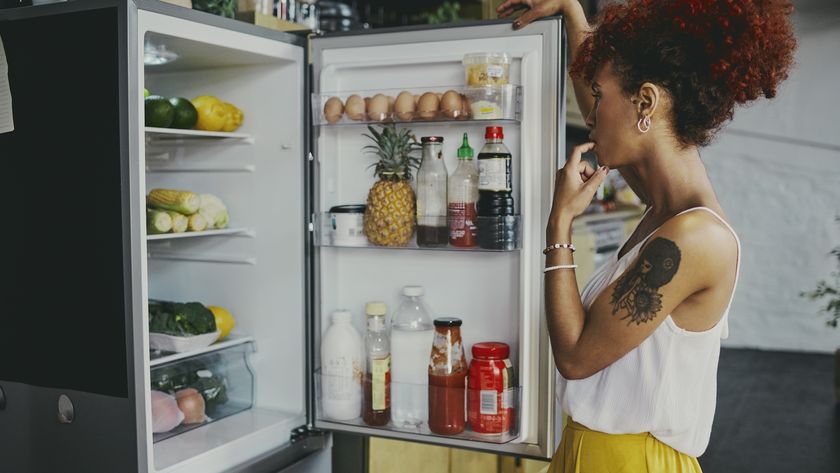 a woman looking in her fridge
