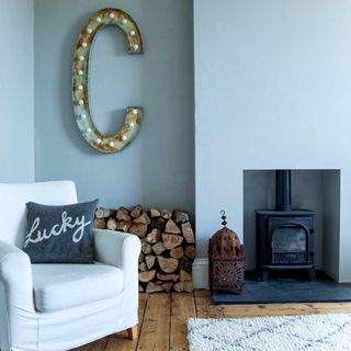 a light blue living room in a Victorian property with original flooring and wood burner - Lizzie Orme