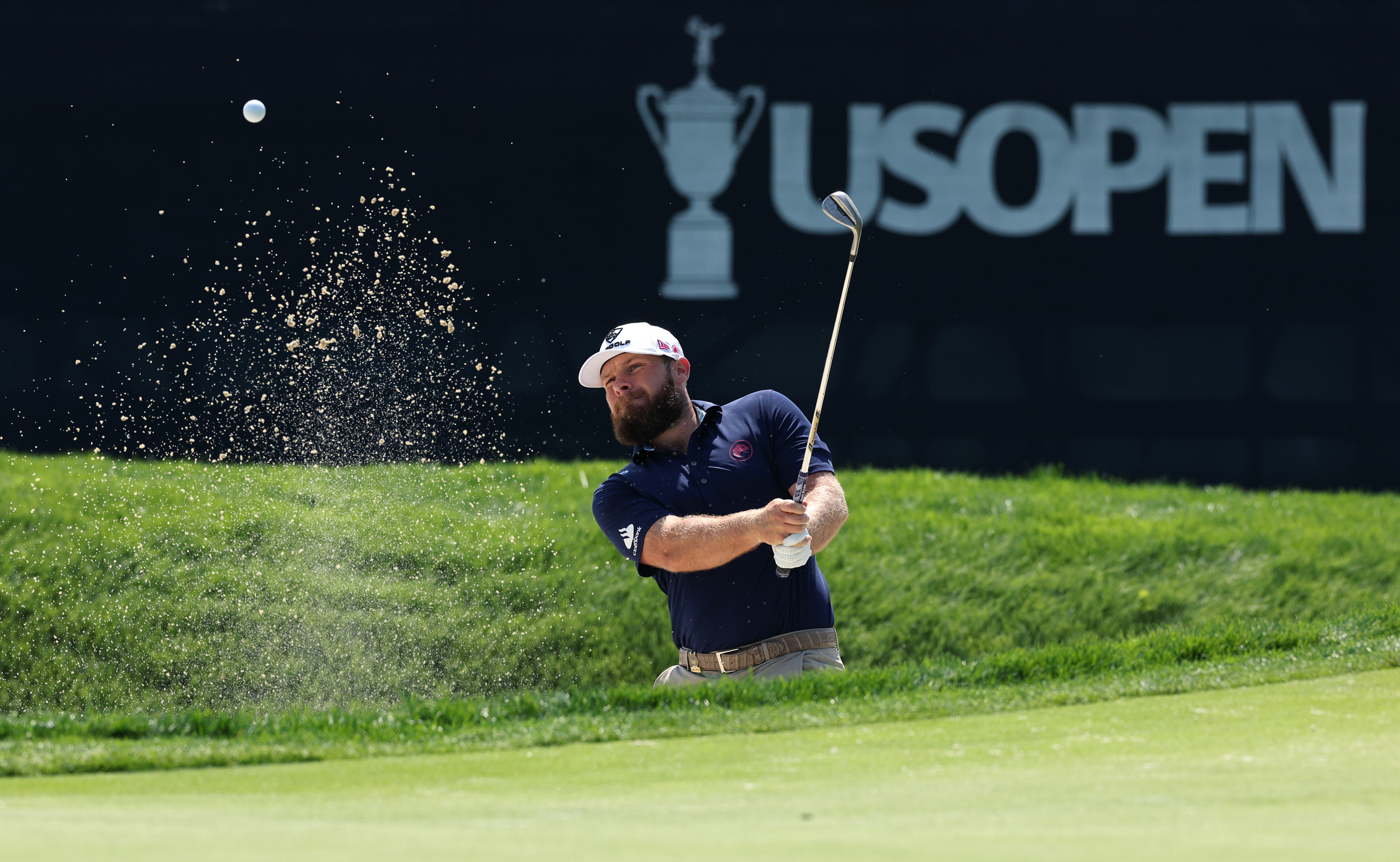 Tyrrell Hatton strikes a bunker shot at the US Open
