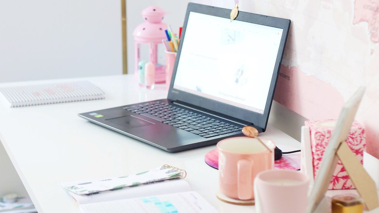 Laptop with pink accessories on desk