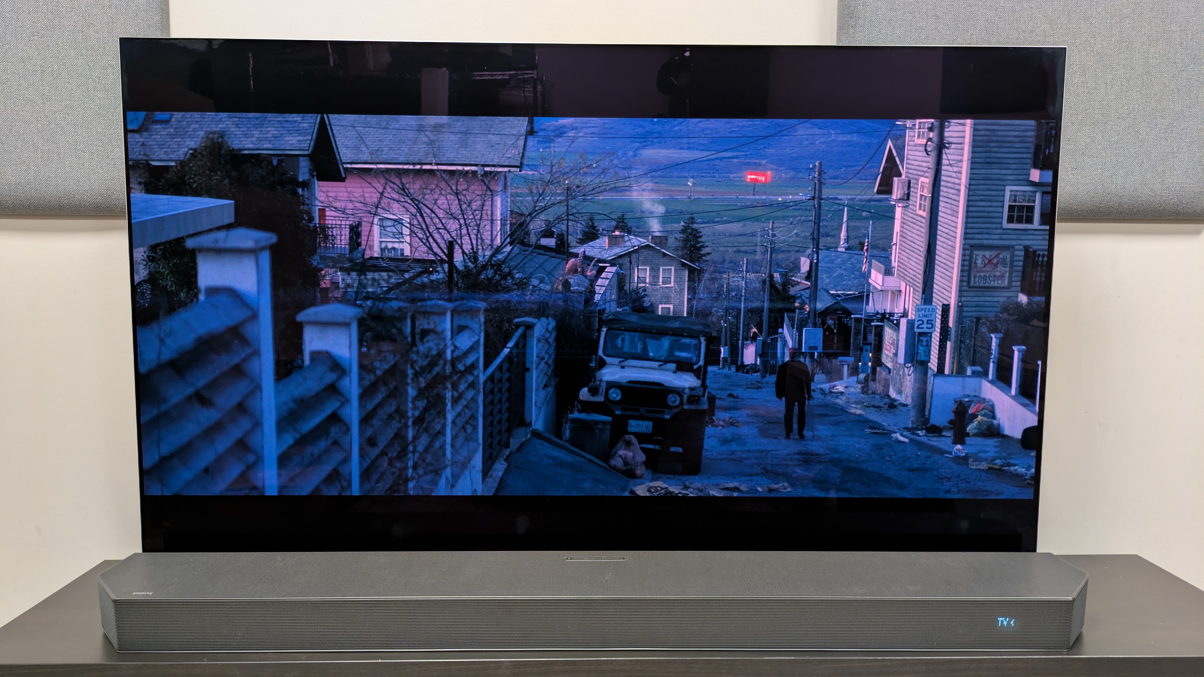 The Running Man (2025) 4K Blu-ray on LG G5 OLED showing Ben walking uphill in a suburb 