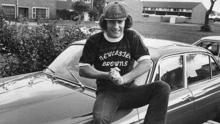 AC/DC’s Brian Johnson sitting on a car in 1980