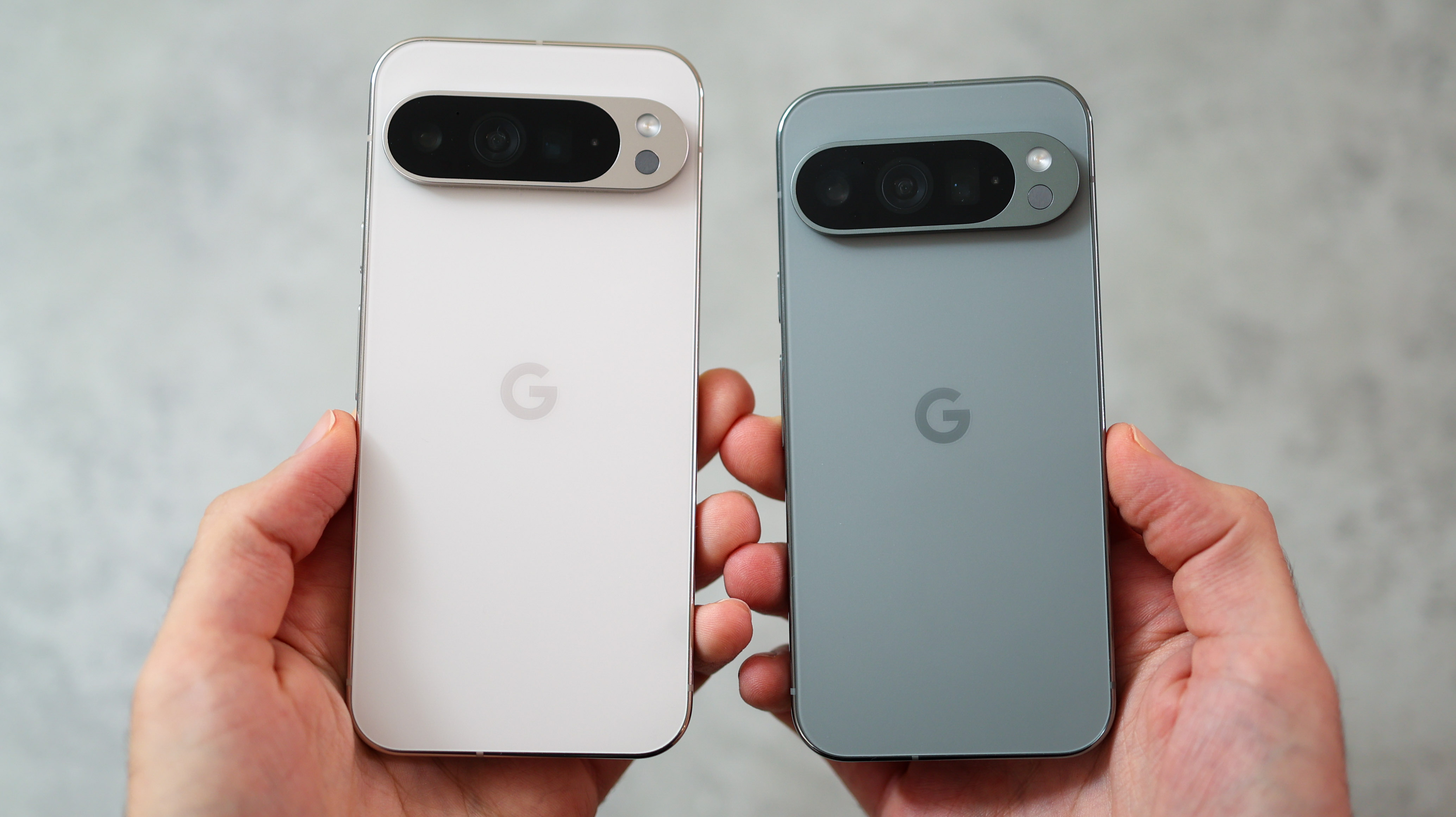 The Google Pixel 9 Pro and 9 Pro XL phones next to each other, both held in a hand