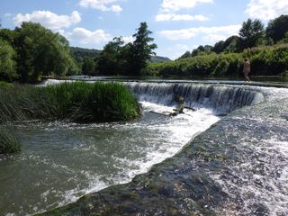 Sample image of a person and dog walking along Warleigh Weir taken with the Pentax WG-90