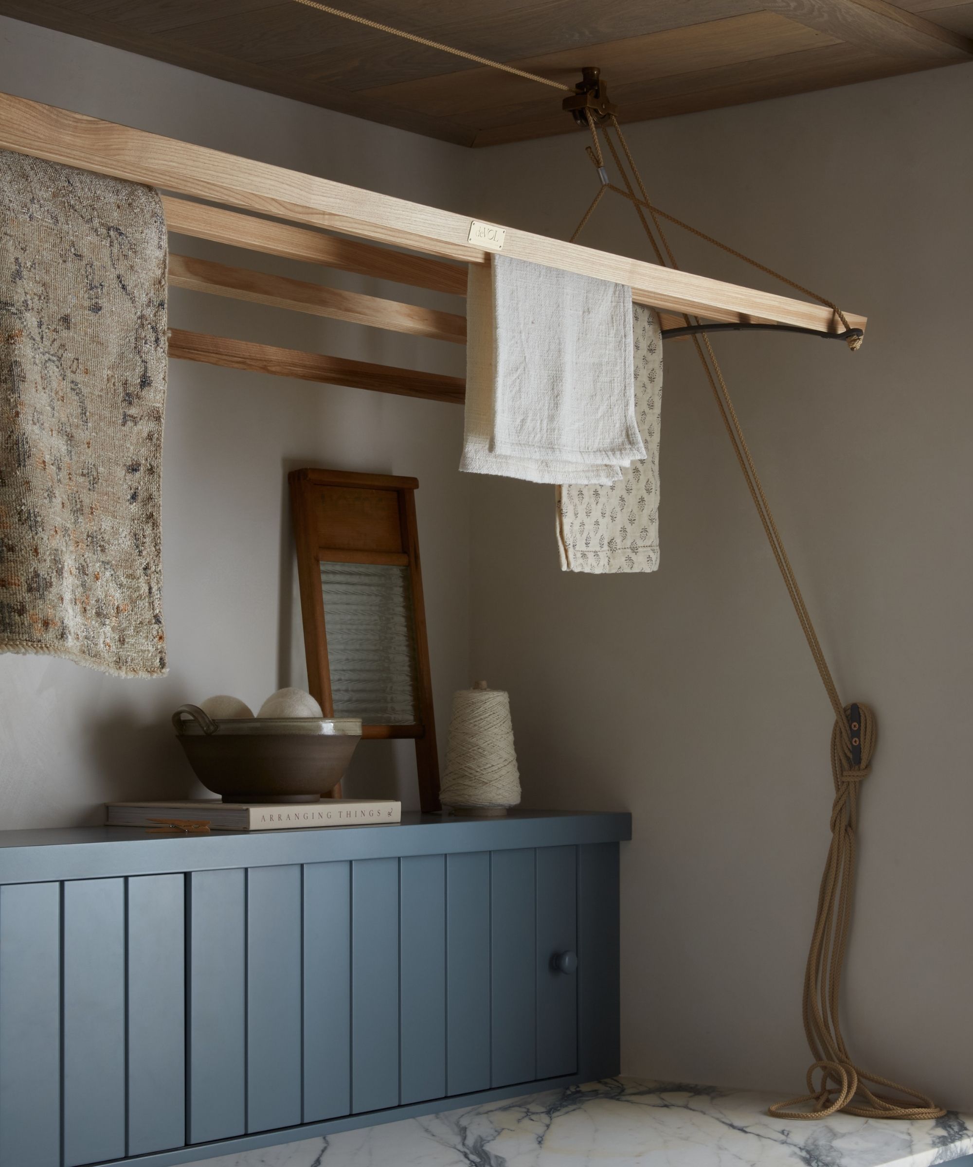 Laundry maid in a white laundry room with blue panelling and marble countertop