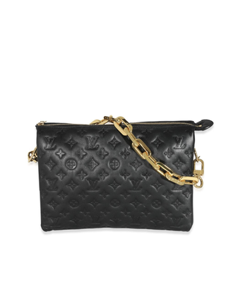 a black louis vuitton bag in front of a plain backdrop