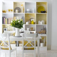 room with white table and chairs and open shelf