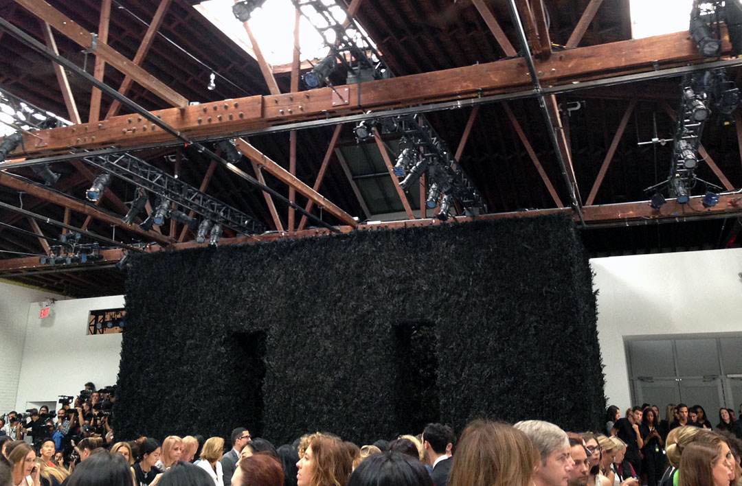 Installation of a runway with a backdrop trellis-covered box burnt to a crisp