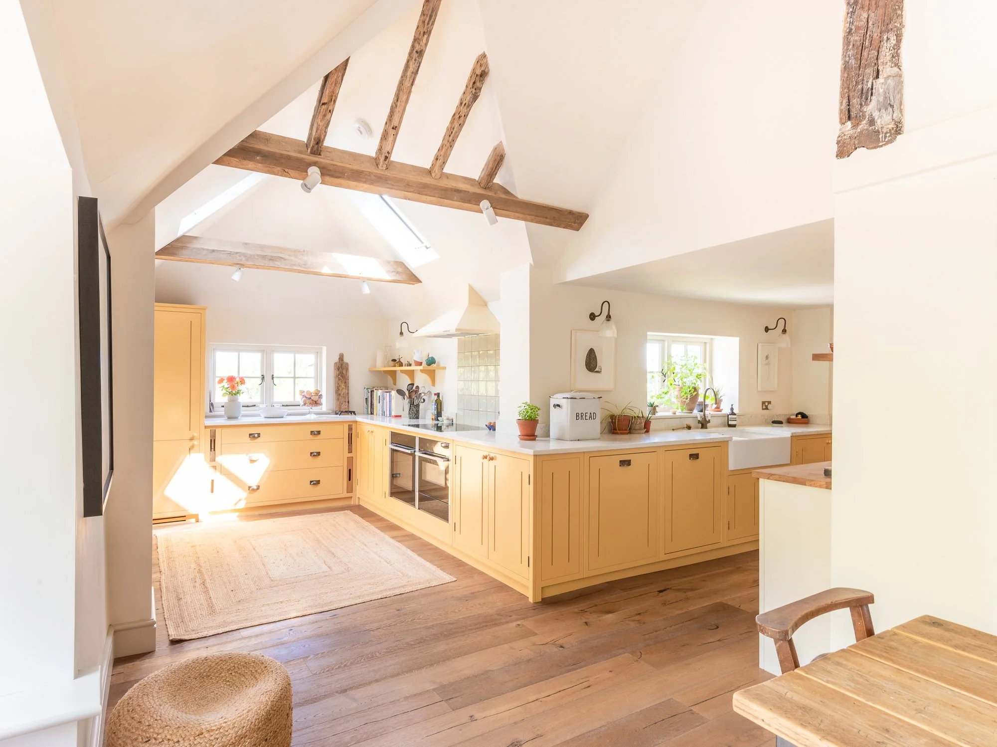 An oak/wood kitchen with lots of drawers and cabinets along the bottom as well as a view of a dining area