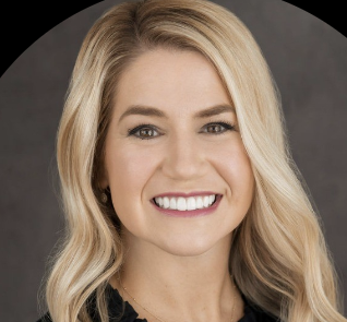 Headshot of a smiling blonde haired woman with a black top