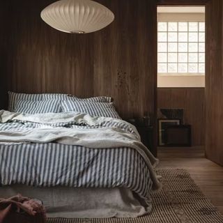 A lifestyle image of the Piglet in BedPembroke Stripe Linen Blend Bedding