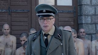 A soldier and prisoners in a Nazi concentration camp in The Photographer of Mauthausen, one of the best Netflix war movies