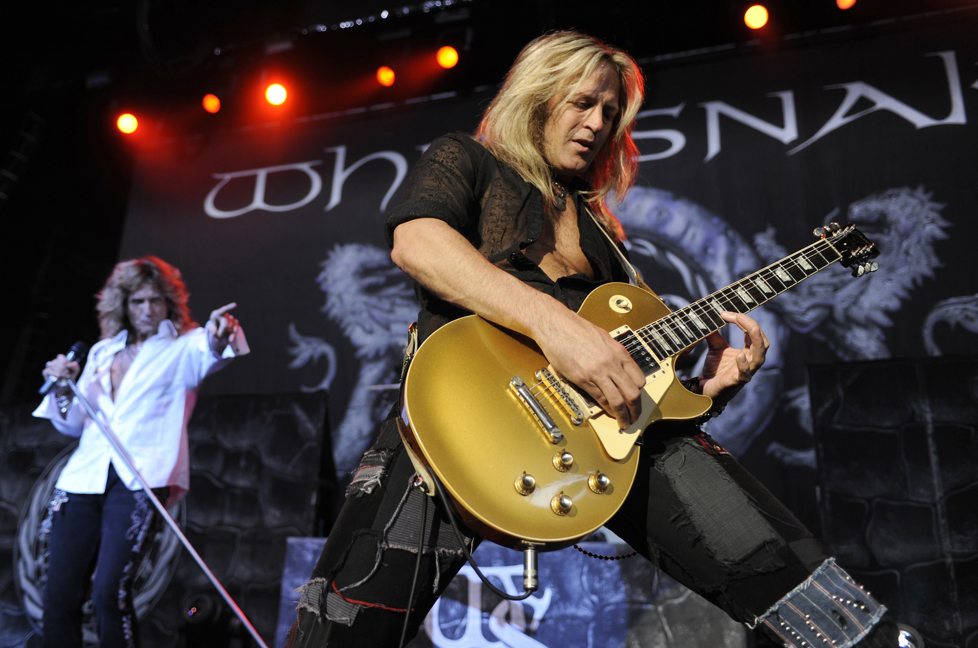 David Coverdale (left, background) points at Doug Aldrich (foreground) as the guitarist takes a solo on his Les Paul – at the Sleep Train Pavilion in Concord, California on July 31, 2009