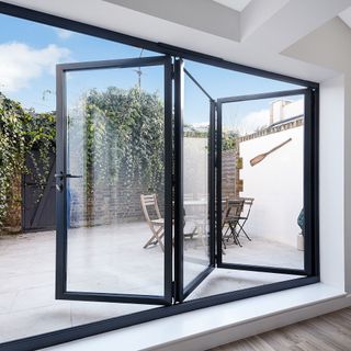 black framed bi-fold doors leading to a small patio