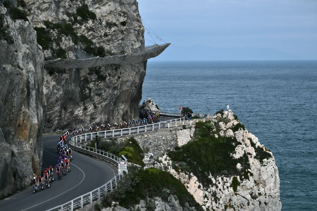 The pack rides along Noli's cape during the Milan - Sanremo one-day classic cycling race, on March 22, 2025. (Photo by Marco BERTORELLO / AFP)