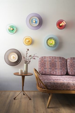 Six Curiousa & Curiousa Siren lights on wall with living room sofa and side table decor