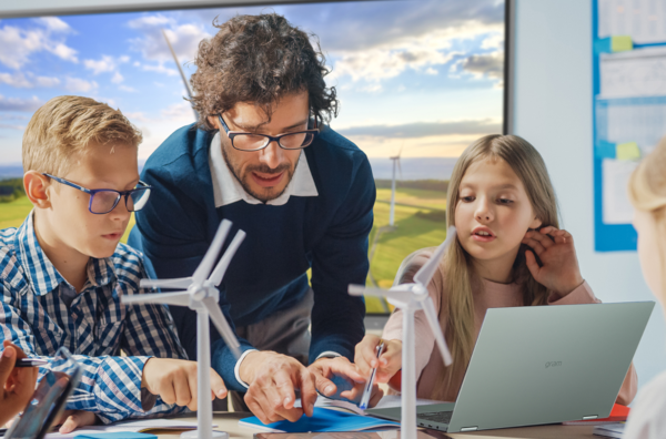 Teachers with three students, laptop computer and model windmills