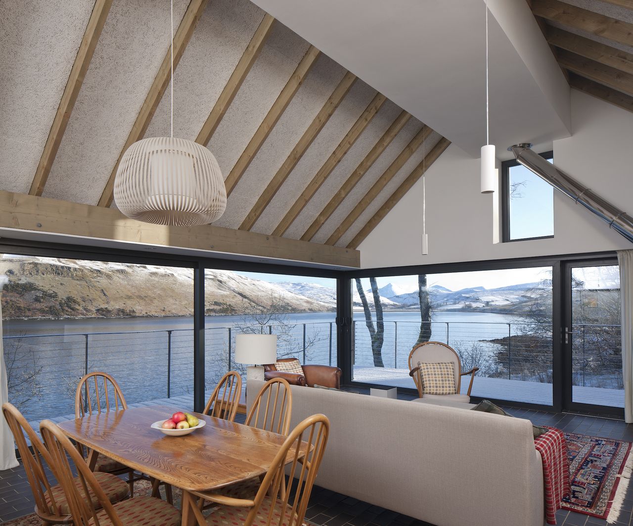 The glass walls slide back into a concealed recess and extend the corner of the room into the open air and views beyond.