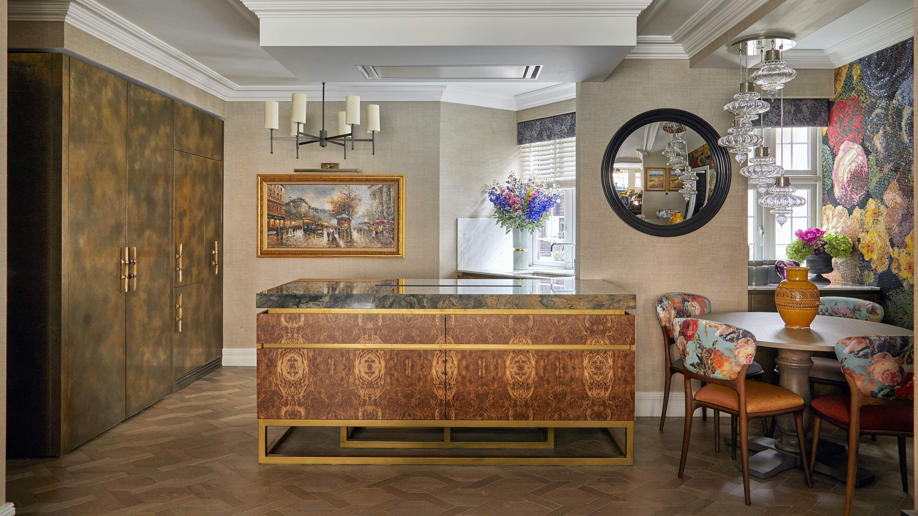hidden kitchen with walnut island and mosaic mural, wood floors, glass chandelier and round mirror