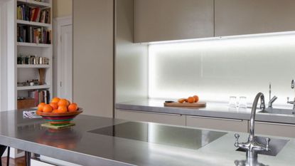 Kitchen with indoor strip lighting under cabinets and stainless steel countertop