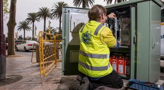 An NBN technician installing NBN in a service box.