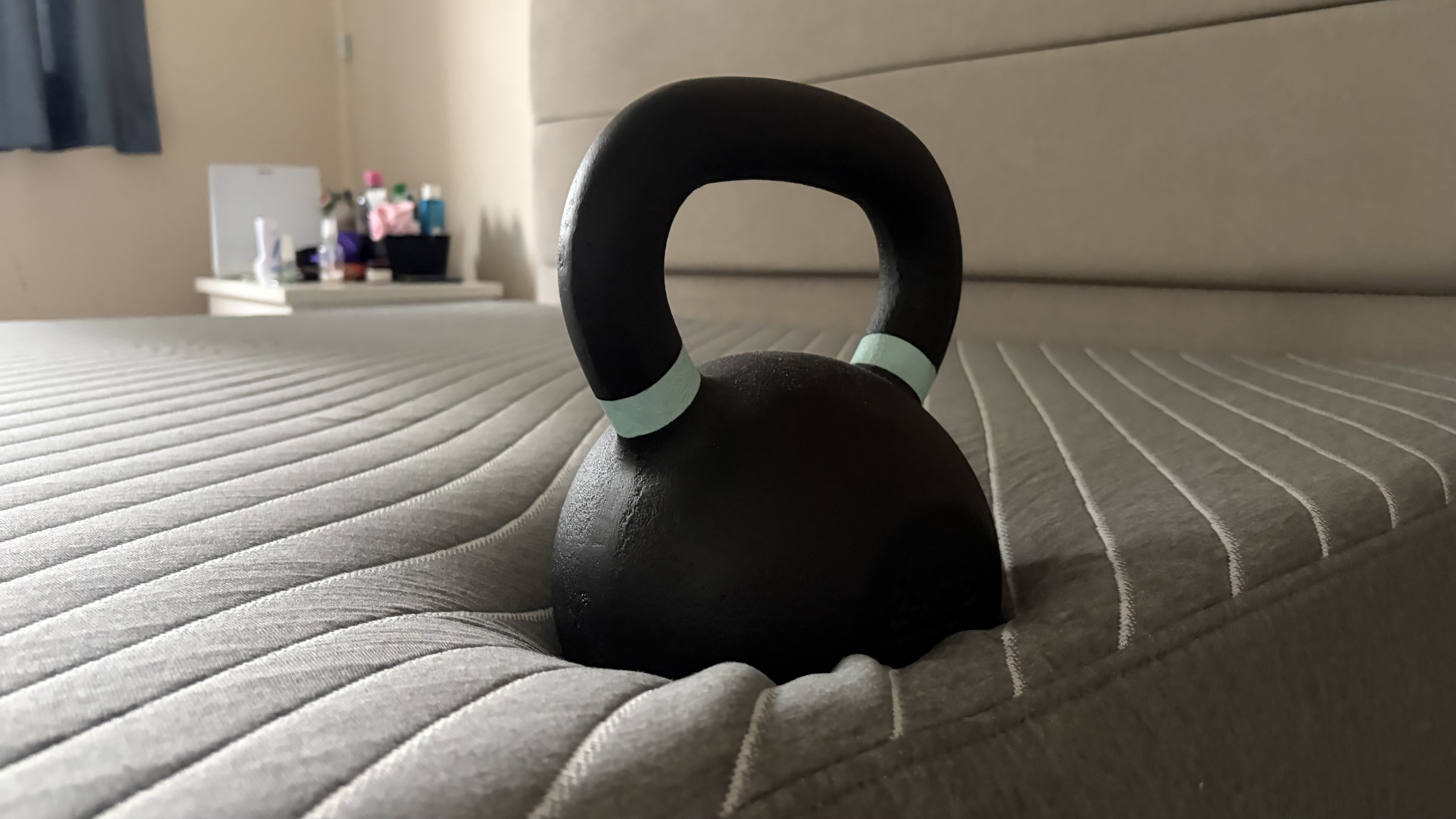 An image of a 25lb weight balanced on the right side of the Siena Signature mattress in the home of our lead tester, Ruth Jones. The weight shows very little sinkage into the mattress